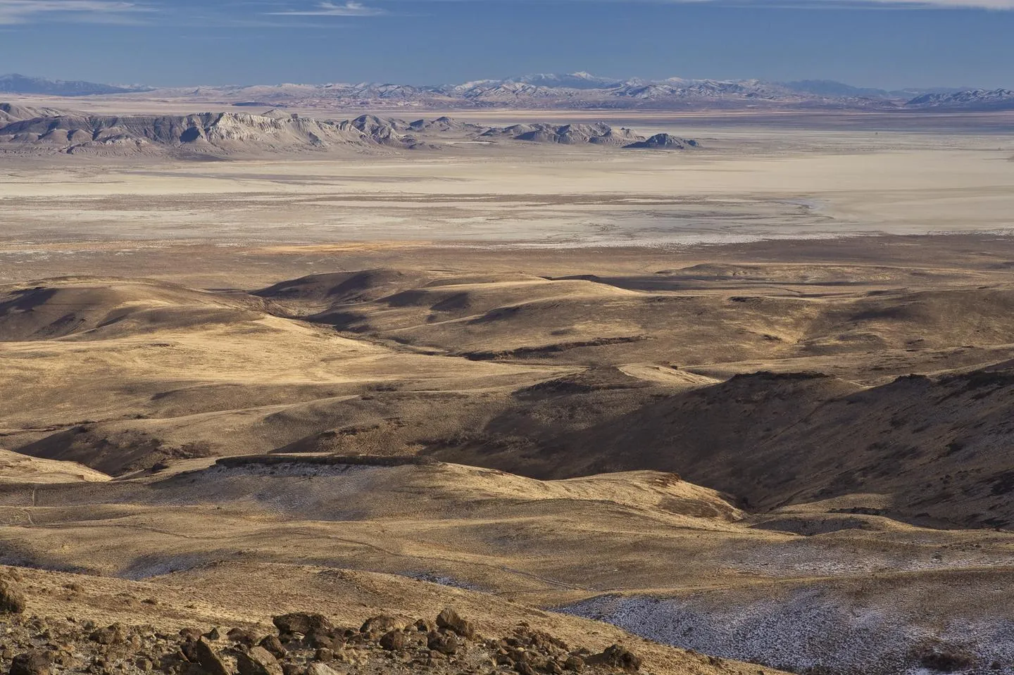 View over brown hills to the pale Black Rock Desert playa and distant mountains in Nevada