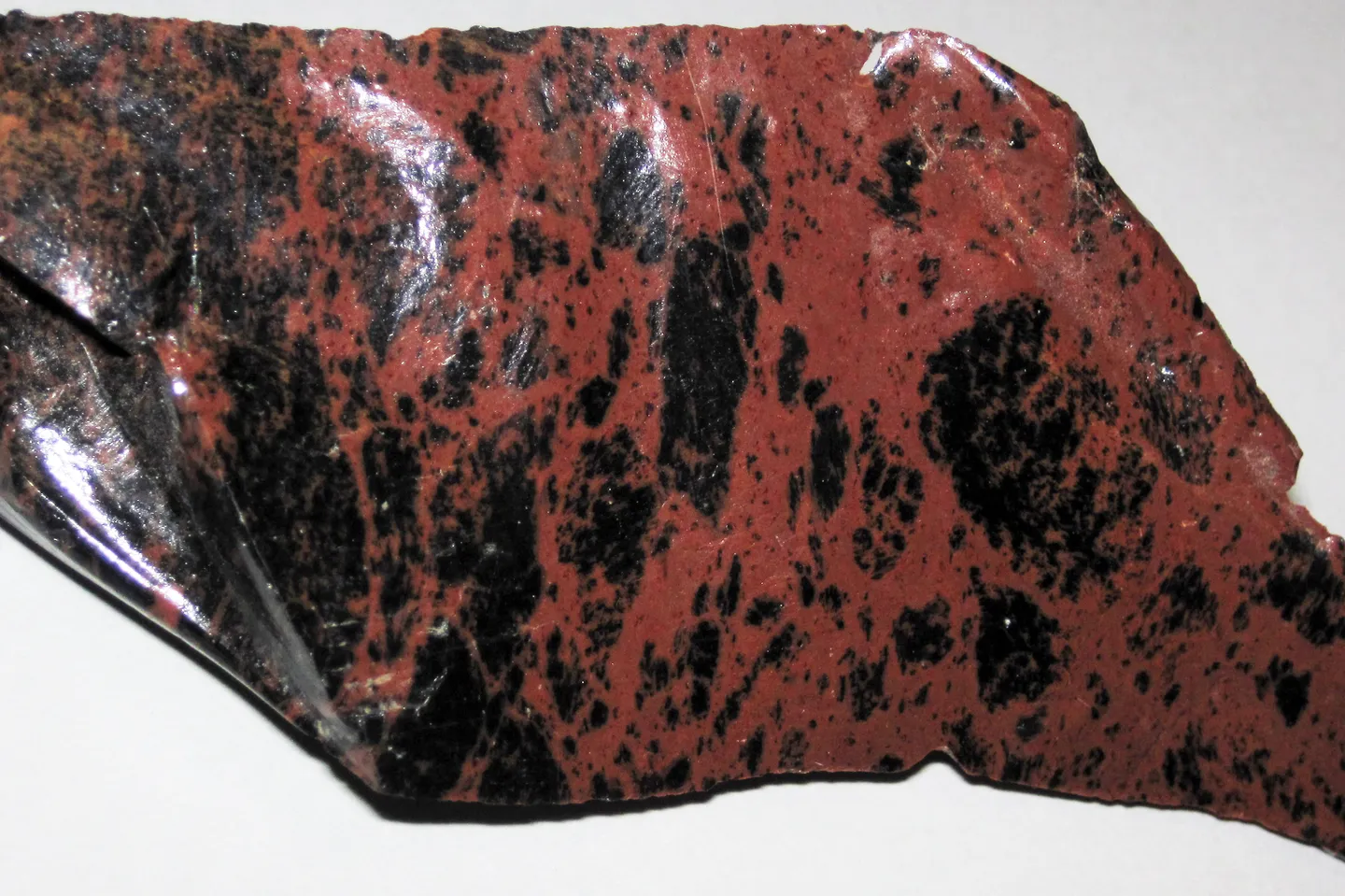 A polished-looking piece of mahogany obsidian, glossy black glass mottled with red-brown, from Glass Buttes, Oregon