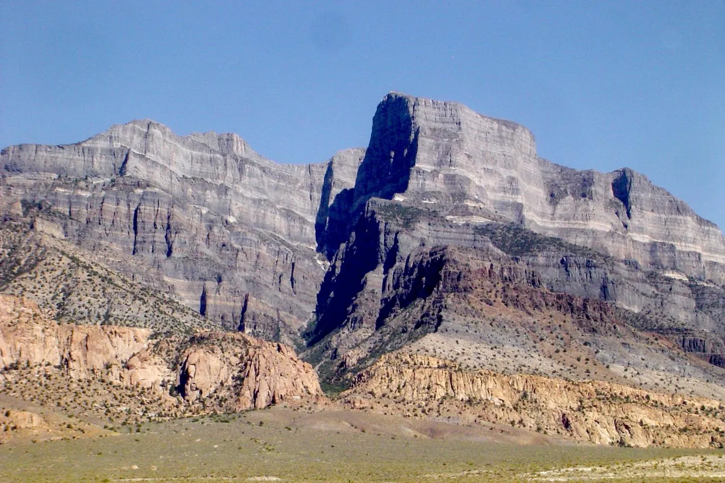 The sheer limestone face of Notch Peak in Utah's House Range under a blue sky